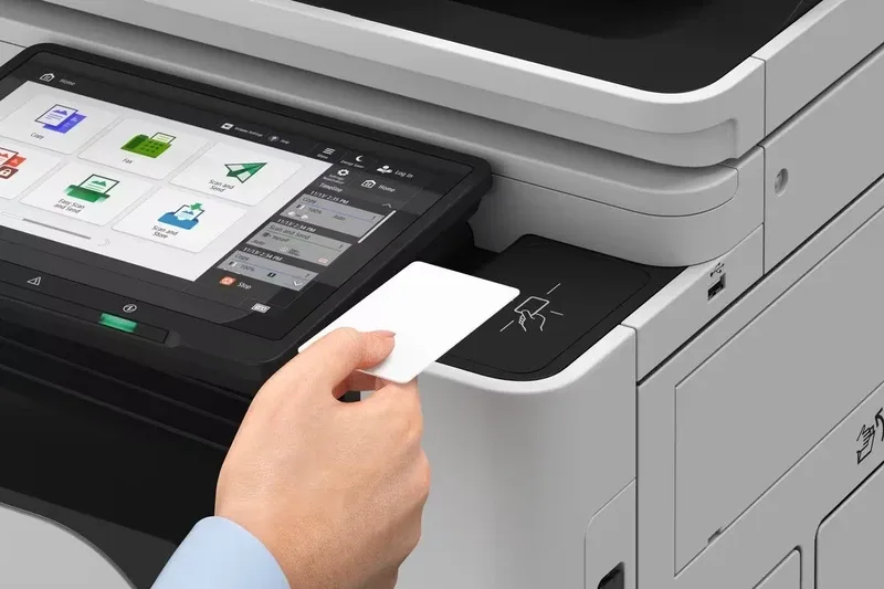 Person tapping an ID card on the Canon imageFORCE C3100 series touch control panel